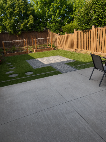 Concrete patio with paver inset, stepping stones and raised garden beds