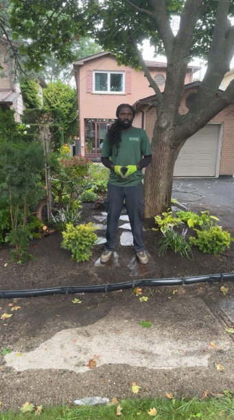 Crew member in a freshly mulched garden bed