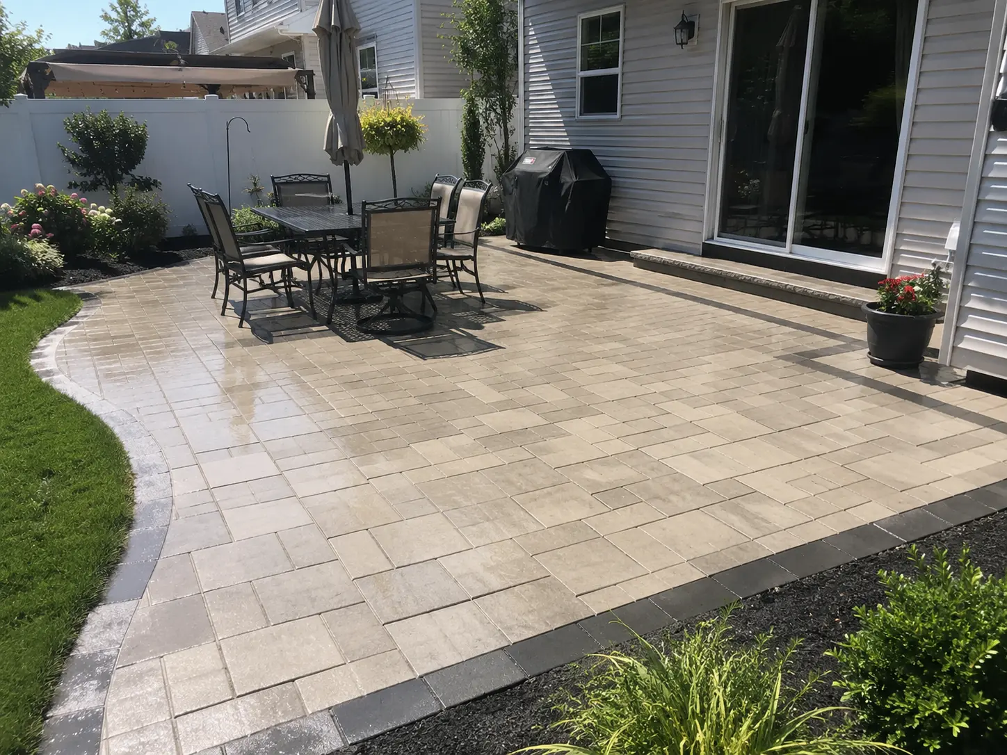 Large paver patio with contrasting border and dining set