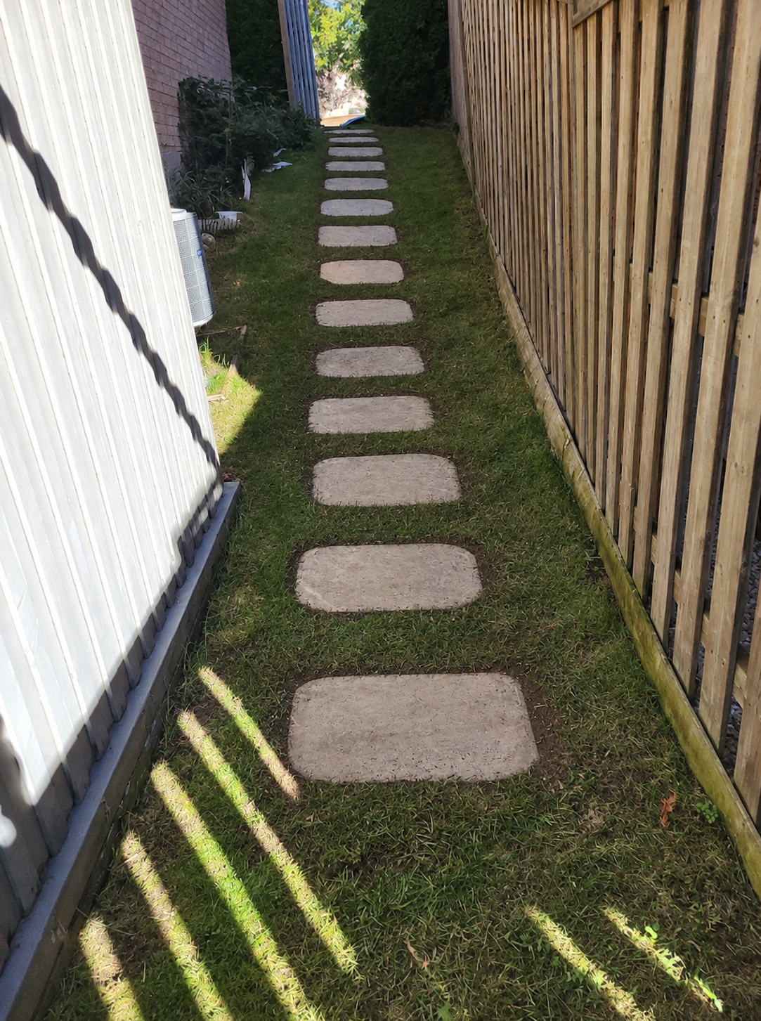 Finished stepping-stone walkway through a landscaped side yard