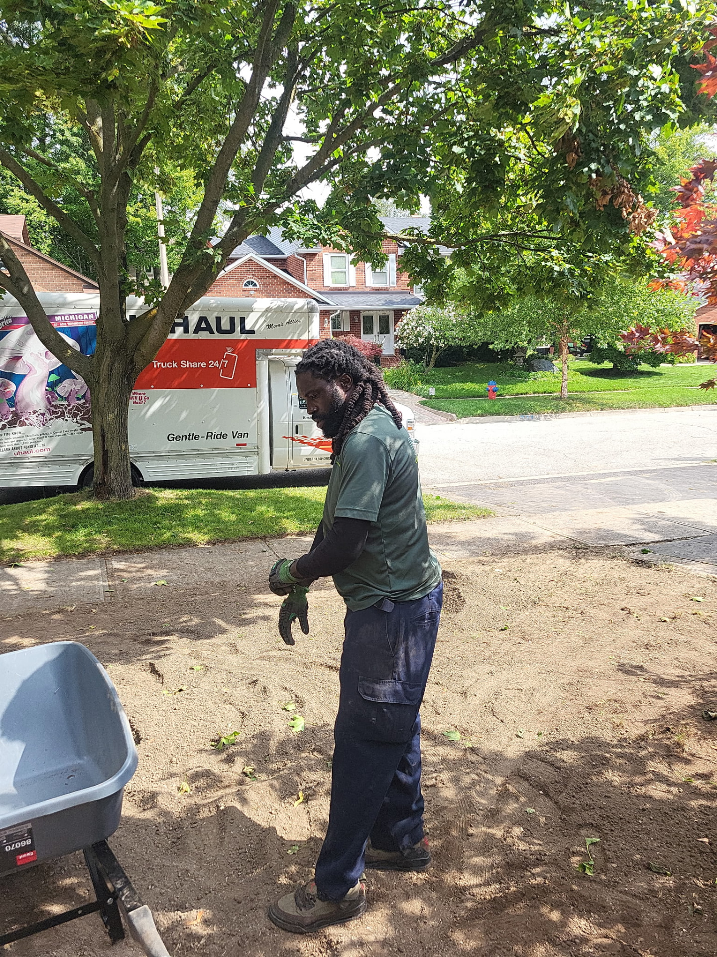 Moving soil by wheelbarrow on a front-yard job